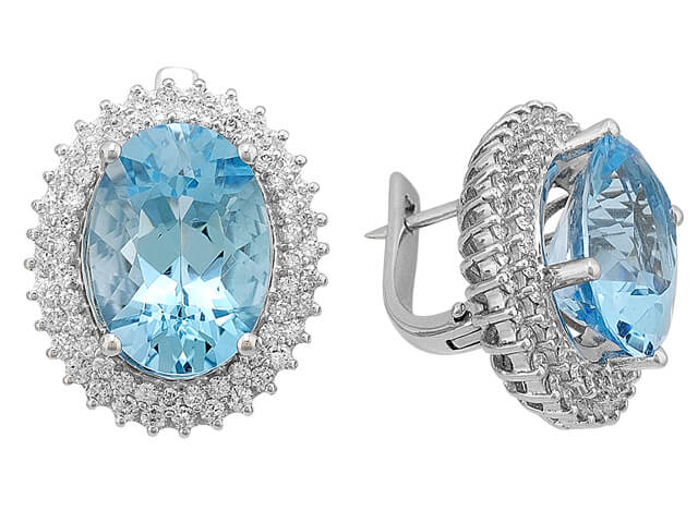 Diamond and oval blue topaz earrings in 14 carat white gold