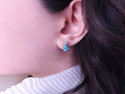 Diamond and oval blue topaz stud earrings in 333 8K gold