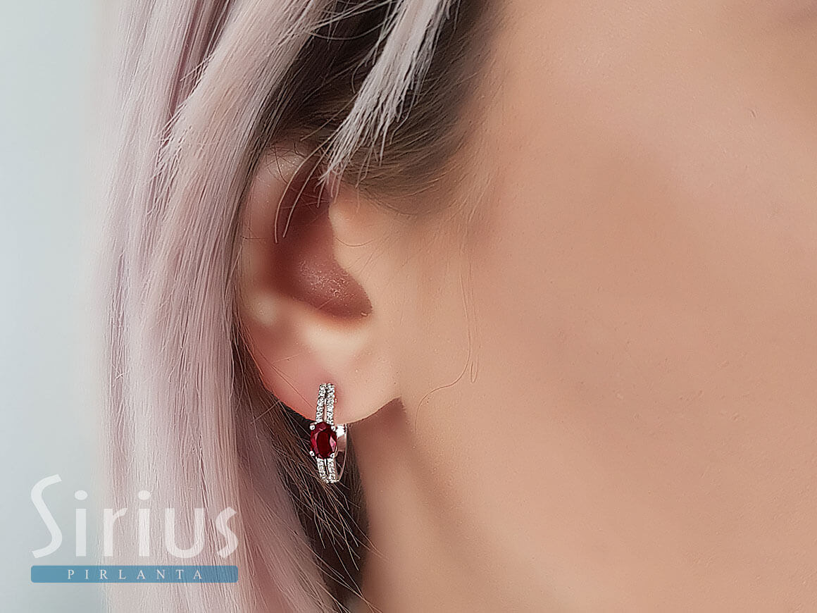 Diamond and oval ruby earrings in 14 carat white gold