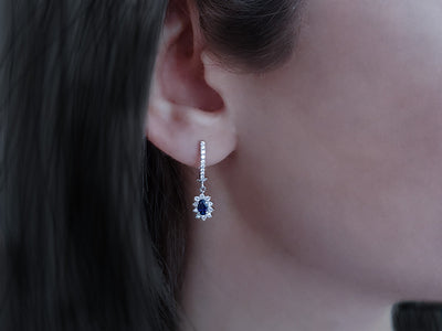 Diamond and oval cut sapphire earrings in 14 carat white gold