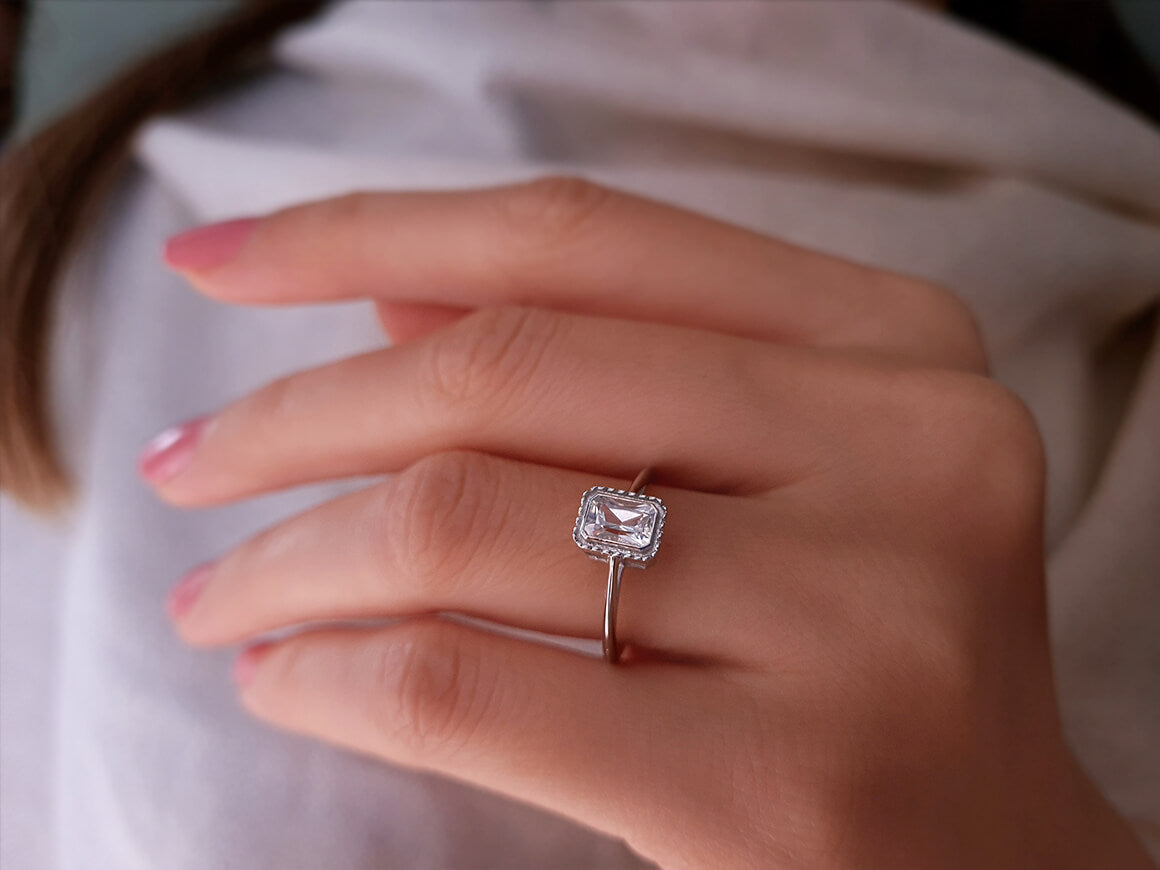 0.70 carat emerald-cut white sapphire solitaire ring in 14k white gold