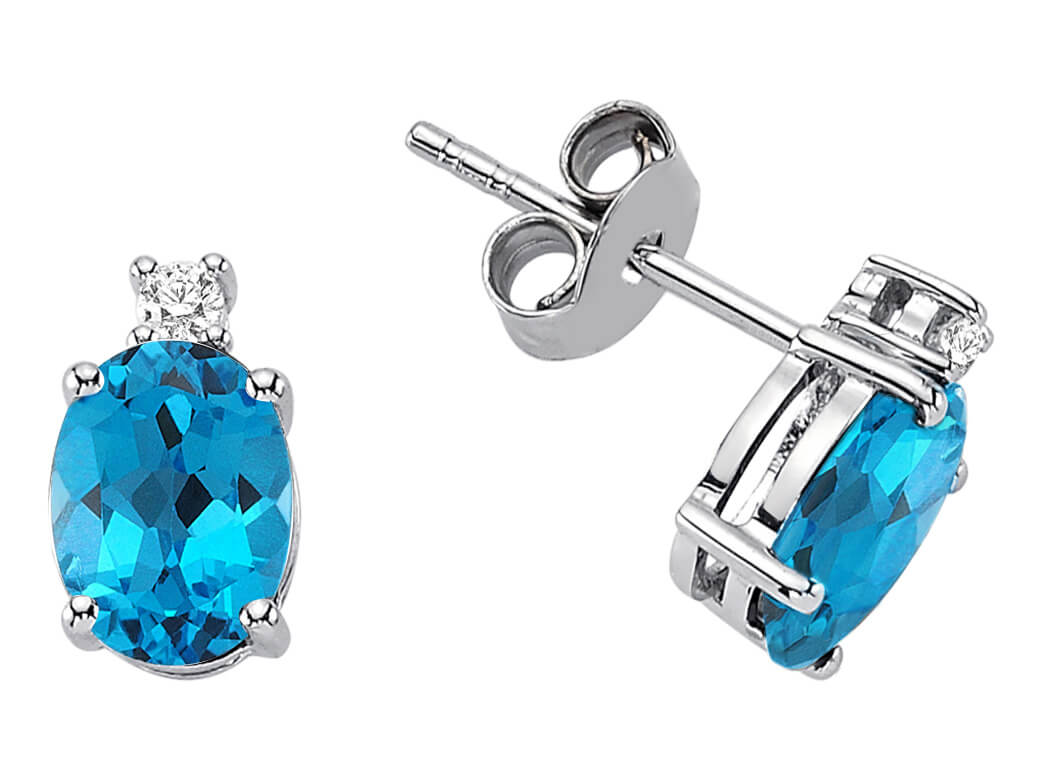 Diamond and oval blue topaz stud earrings in 333 white gold