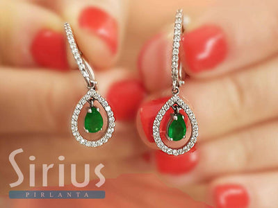Diamond and drop emerald earrings in 14 carat white gold