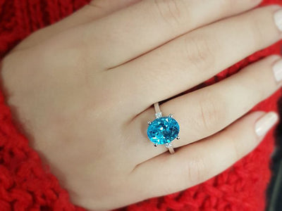 Diamond and oval blue topaz ring in 14 carat white gold